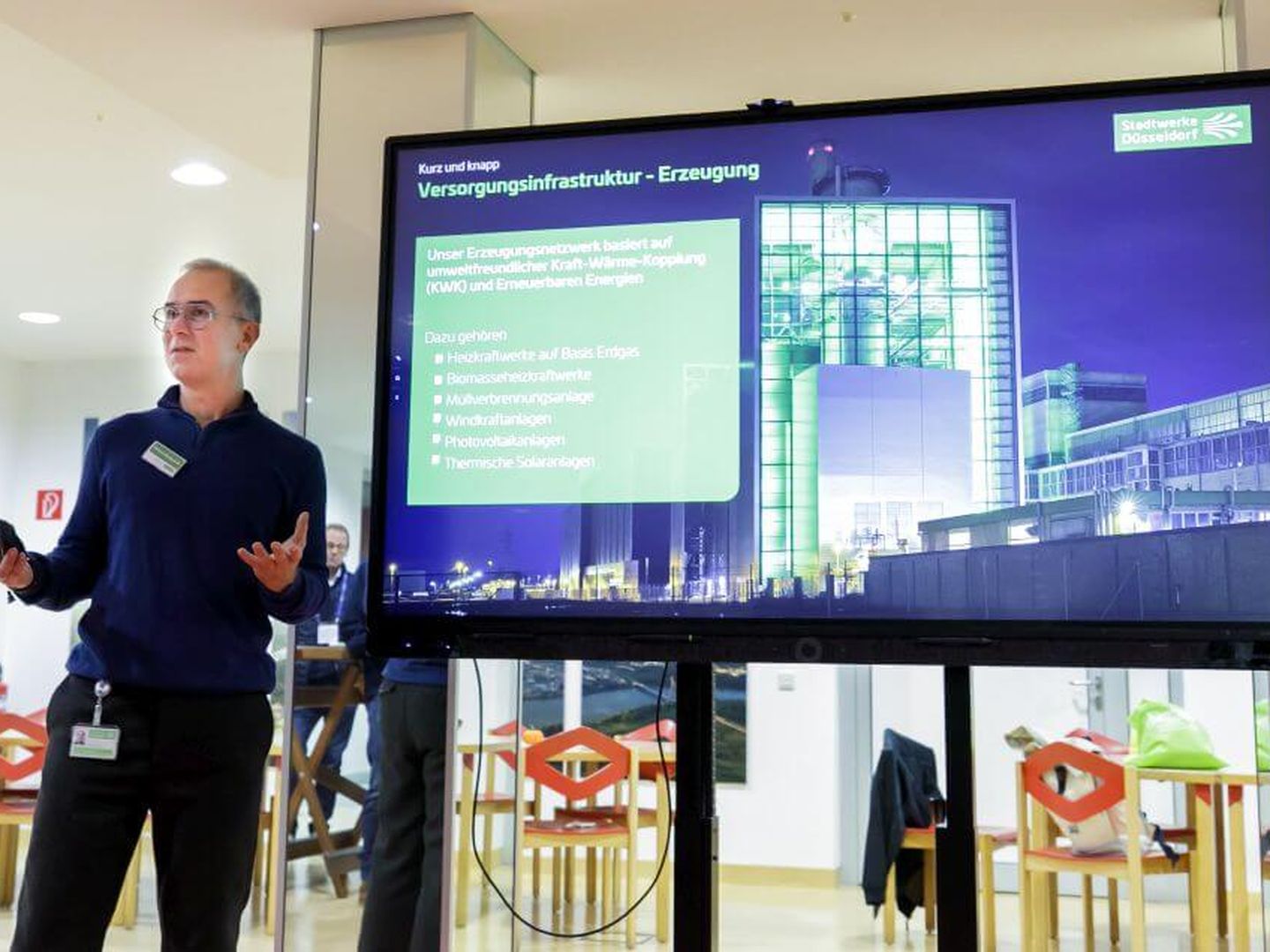 Ein Stadtwerke-Mitarbeiter hält einen Vortrag zur Versorgungsinfrastruktur vor einem großen Bildschirm. © Stadtwerke Düsseldorf