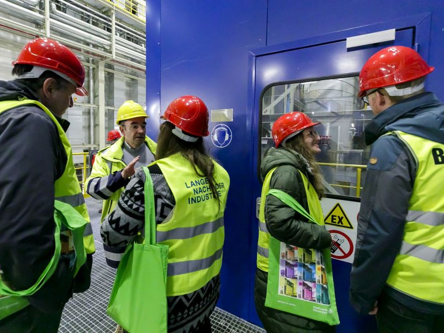 Besucher:innen mit Sicherheitswesten und Helmen im Gespräch mit einem Mitarbeiter der Stadtwerke Düsseldorf. © Stadtwerke Düsseldorf © Stadtwerke Düsseldorf