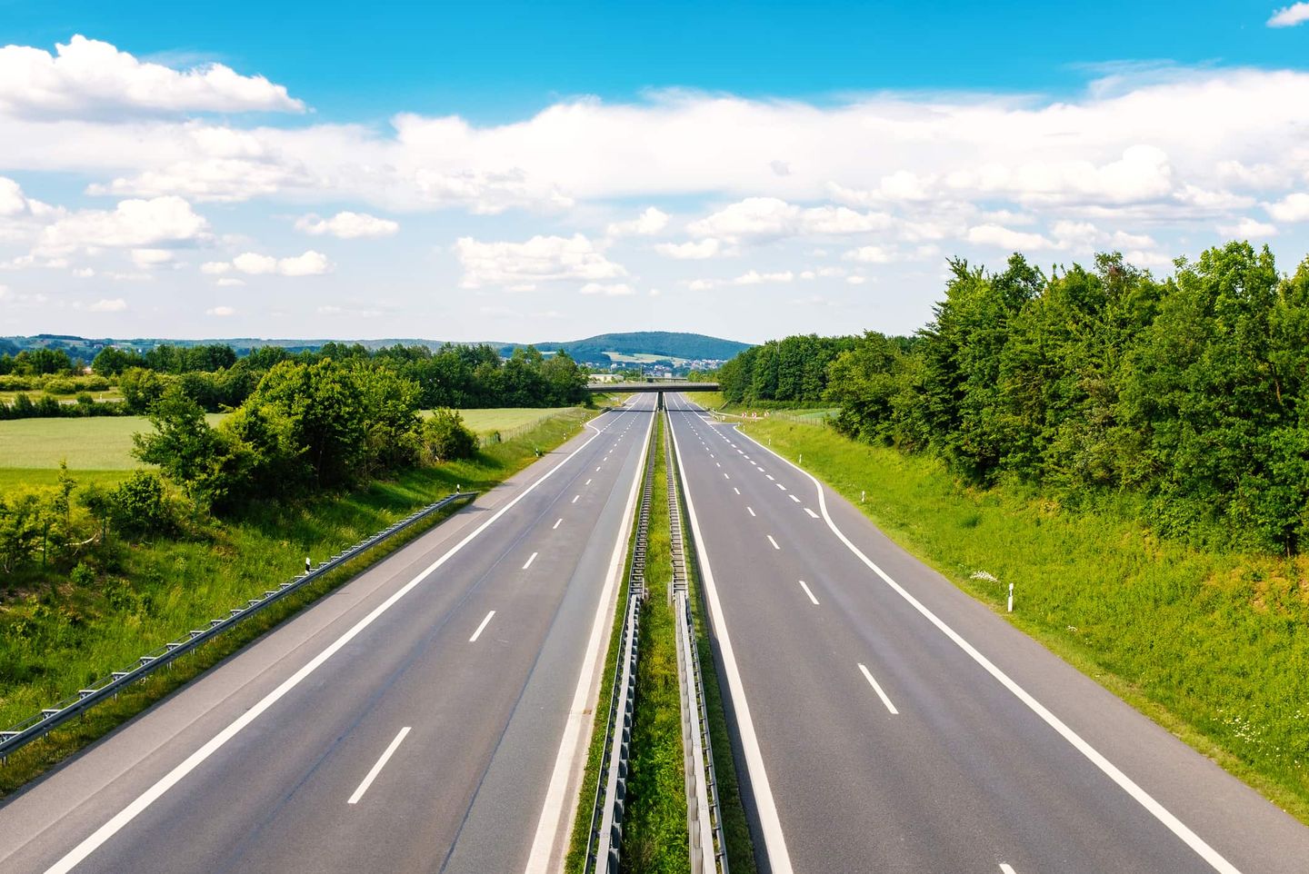 Leere Autobahn mit grüner Landschaft und blauem Himmel. Getty