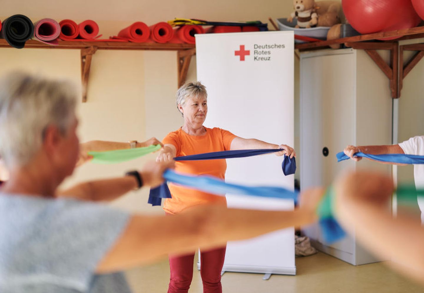 Seniorinnen machen Sportübungen mit einem elastischen Band.