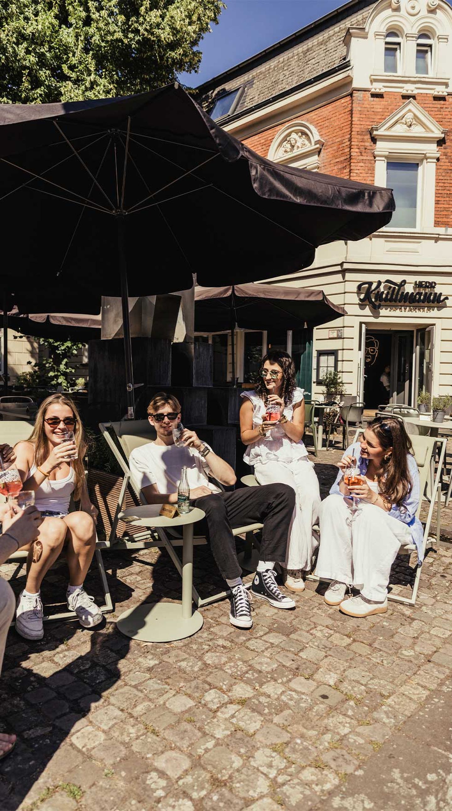 Gäste trinken im Sonnenschein bei Herr Knillmann