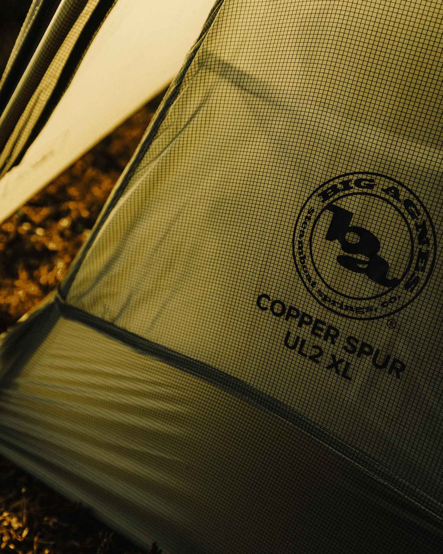 Close-up of a tent fabric with the logo and text "Copper Spur UL2 XL" visible on a mesh panel.