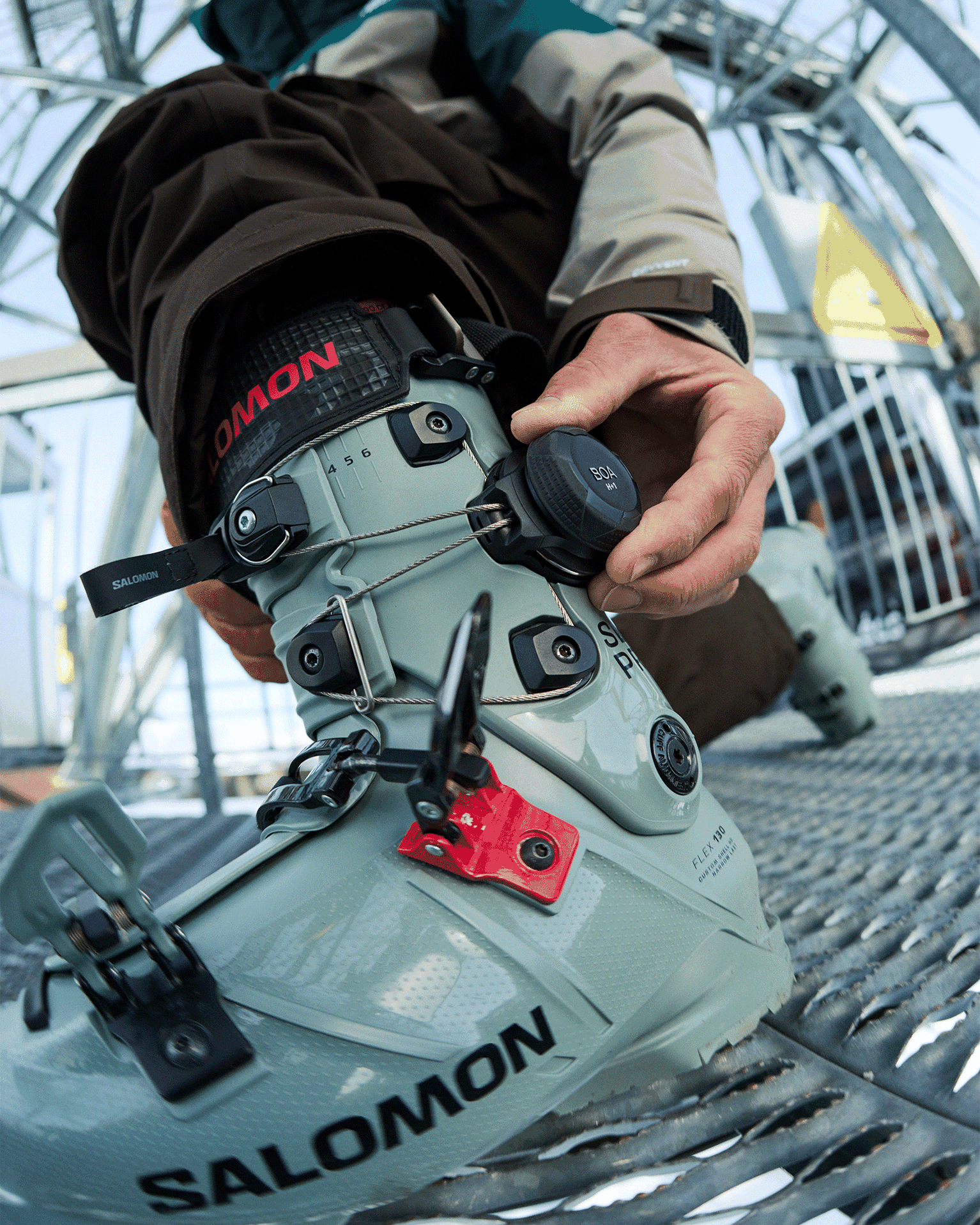 Close-up of a person adjusting a ski boot with advanced fastening features.
