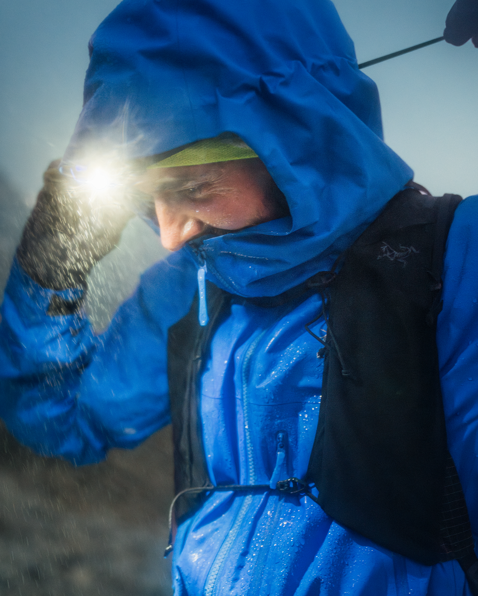 Man wearing Arc'teryx Beta SV Jacket adjusts the hood against the rain