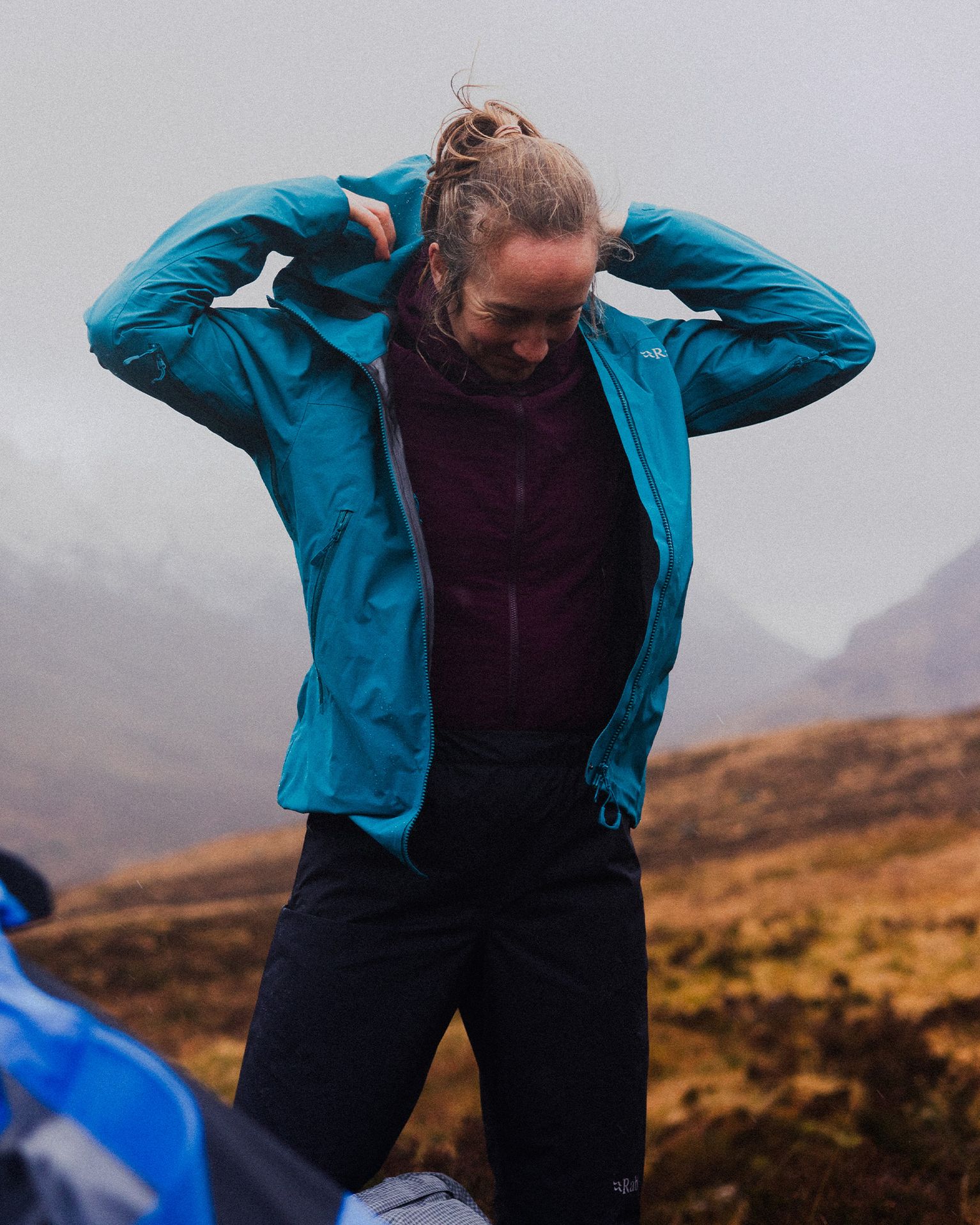 hiker putting on a waterproof jacket