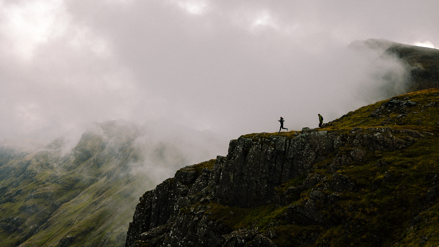 two trail runners running on a fell