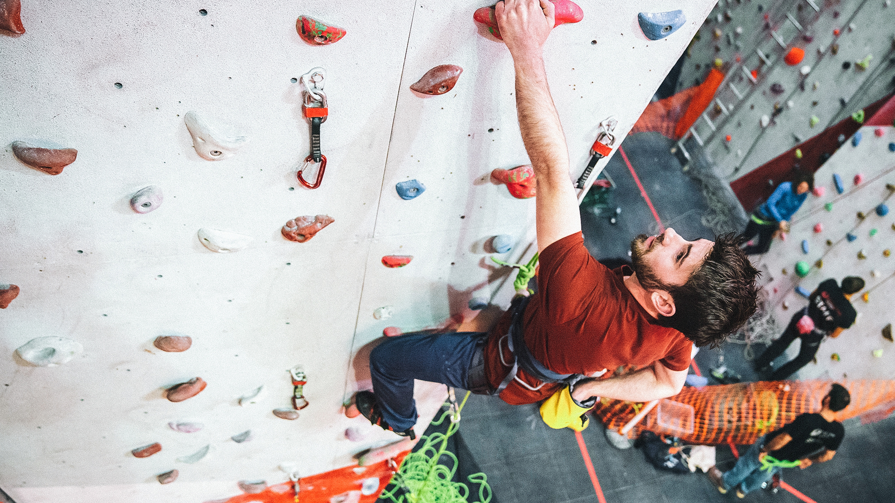 man sport climbing at an indoor climbing wall