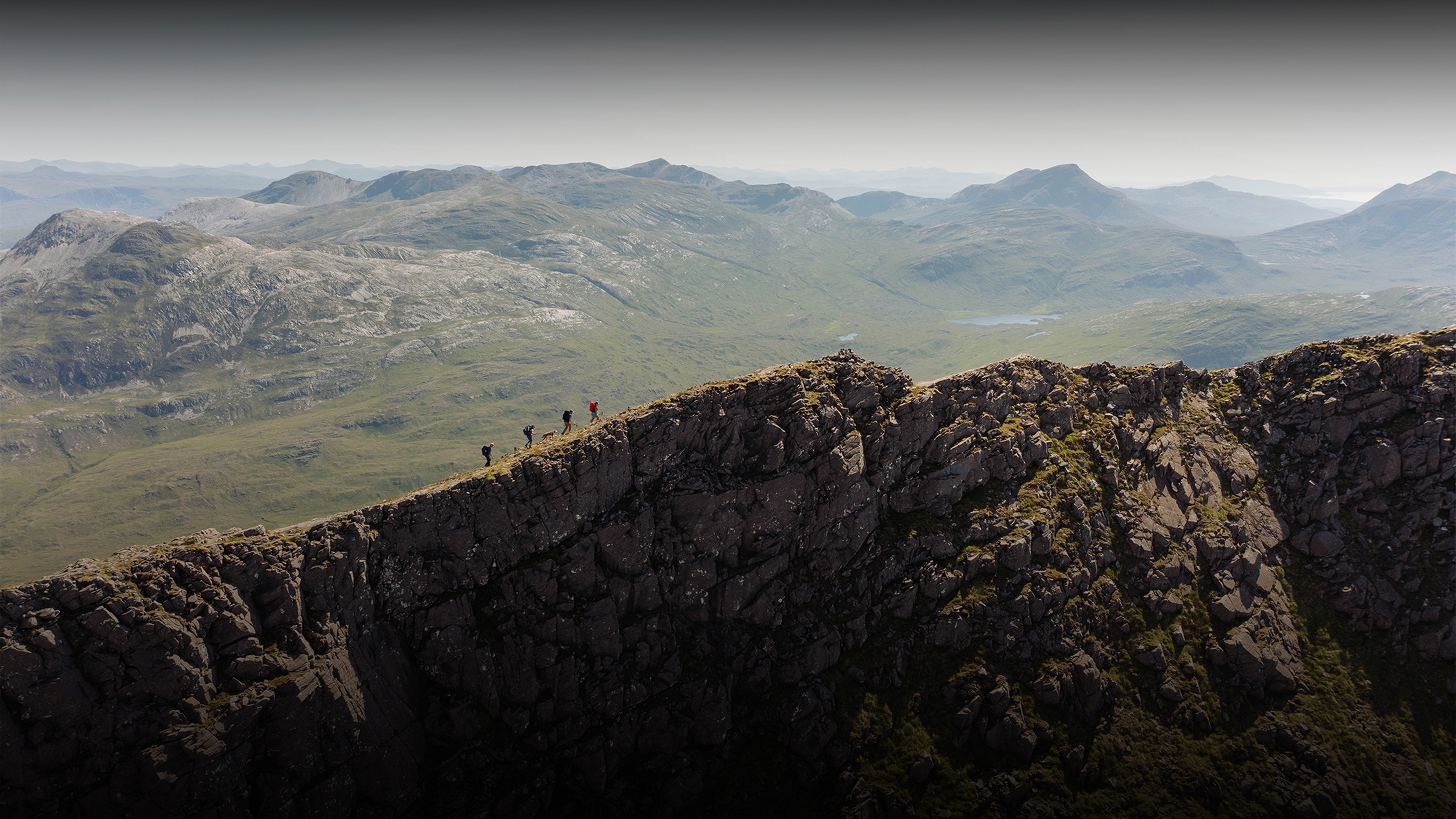 4 people walking along a ridge