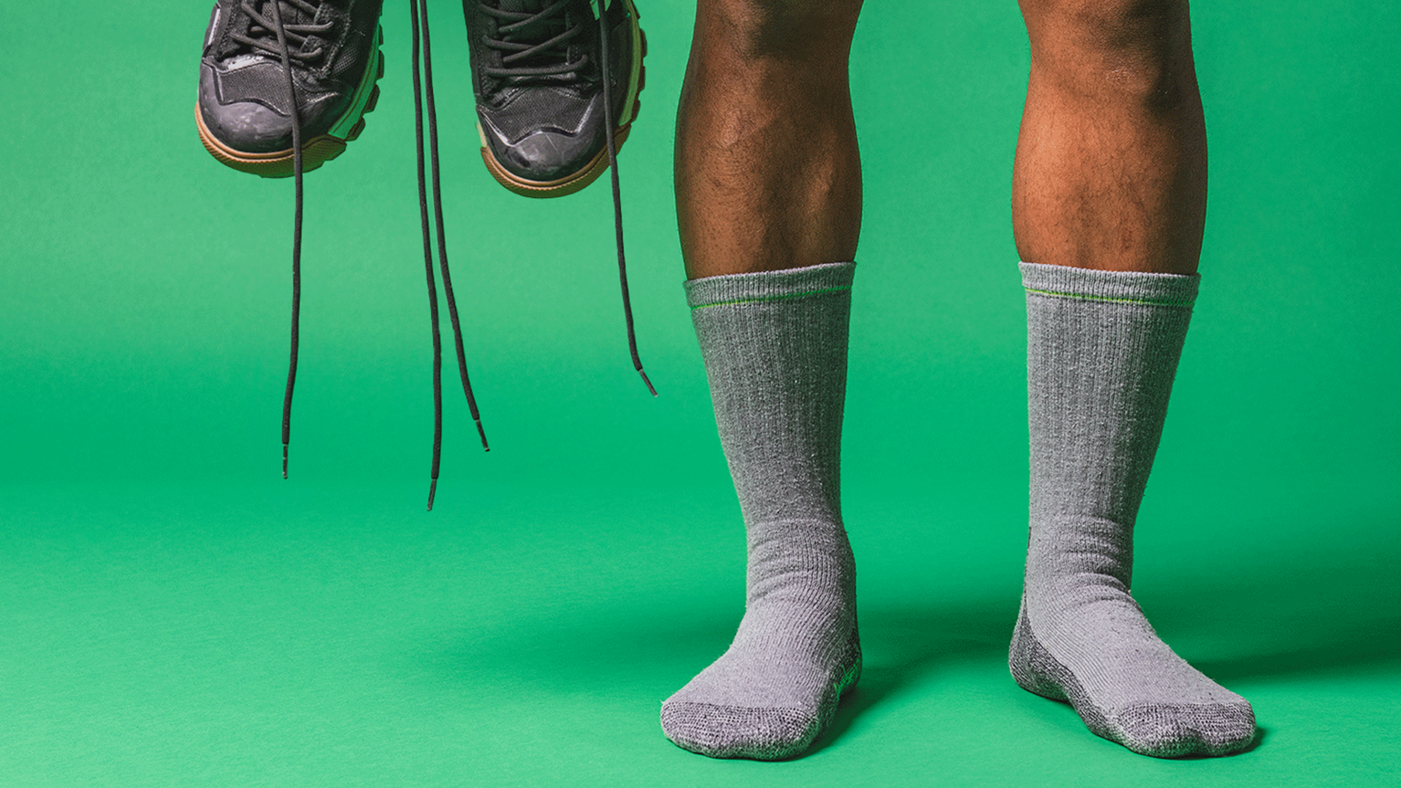 Person in socks in front of green background