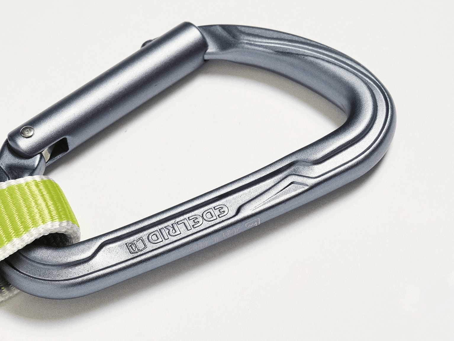 Silver carabiner with a green and white strap attached, set against a plain background.