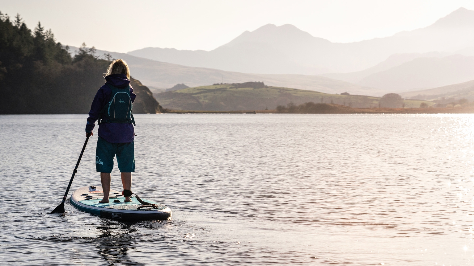 person paddleboarding on lake