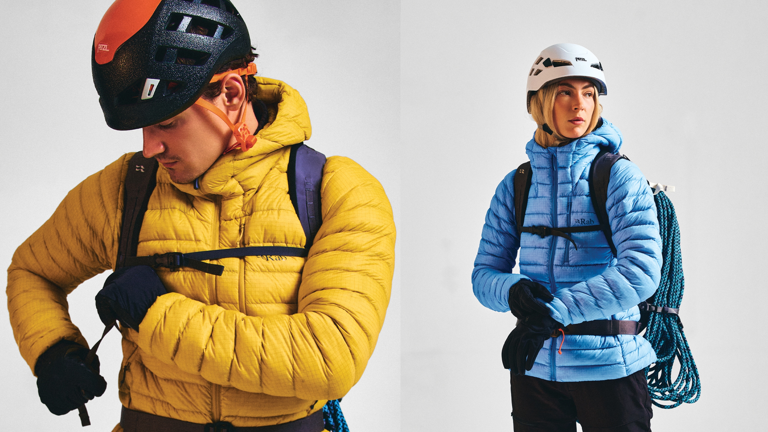 Two climbers in helmets and insulated jackets, one in yellow and one in blue, gearing up for a mountain adventure.