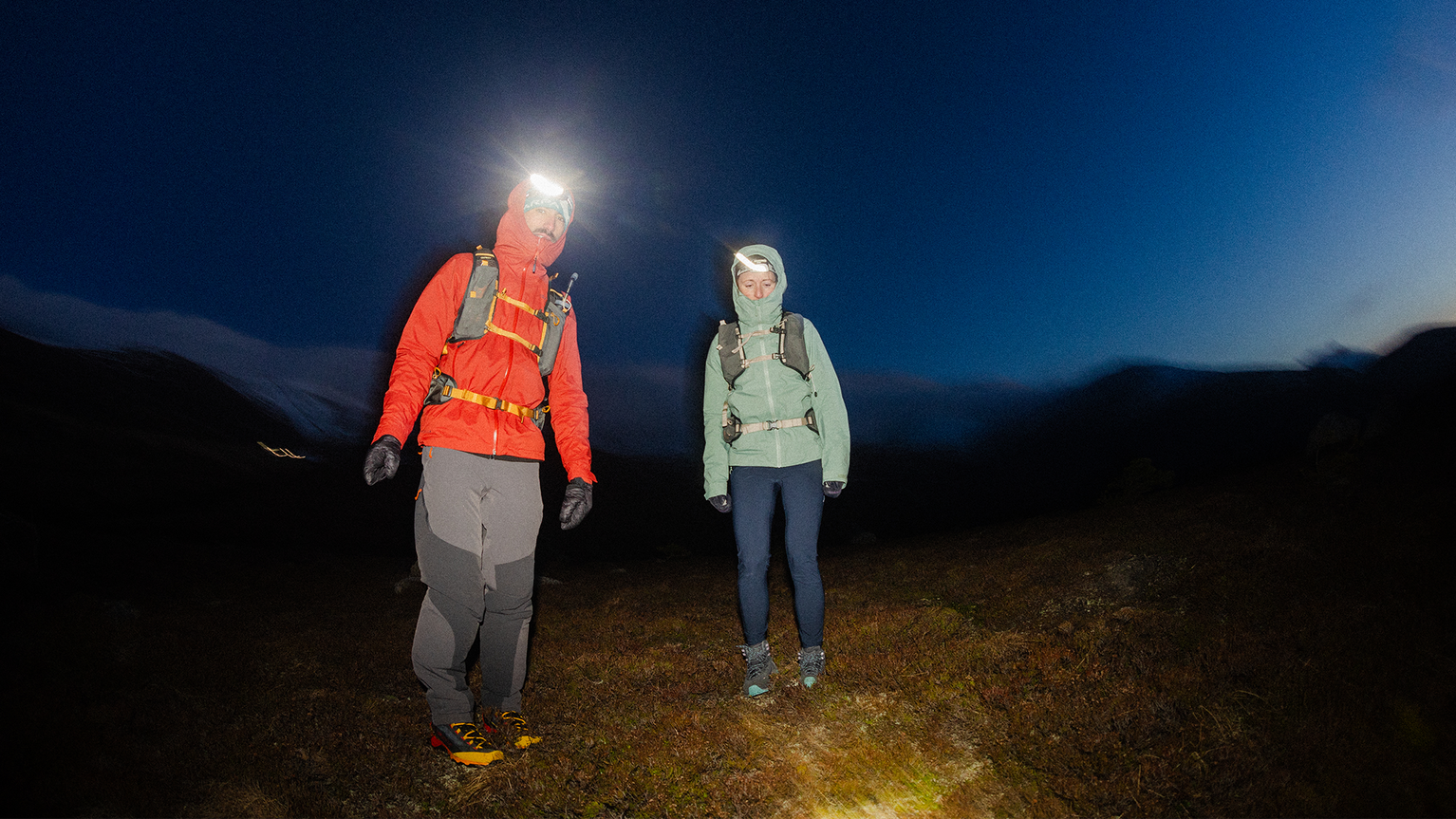 two people wearing head torches in the dark