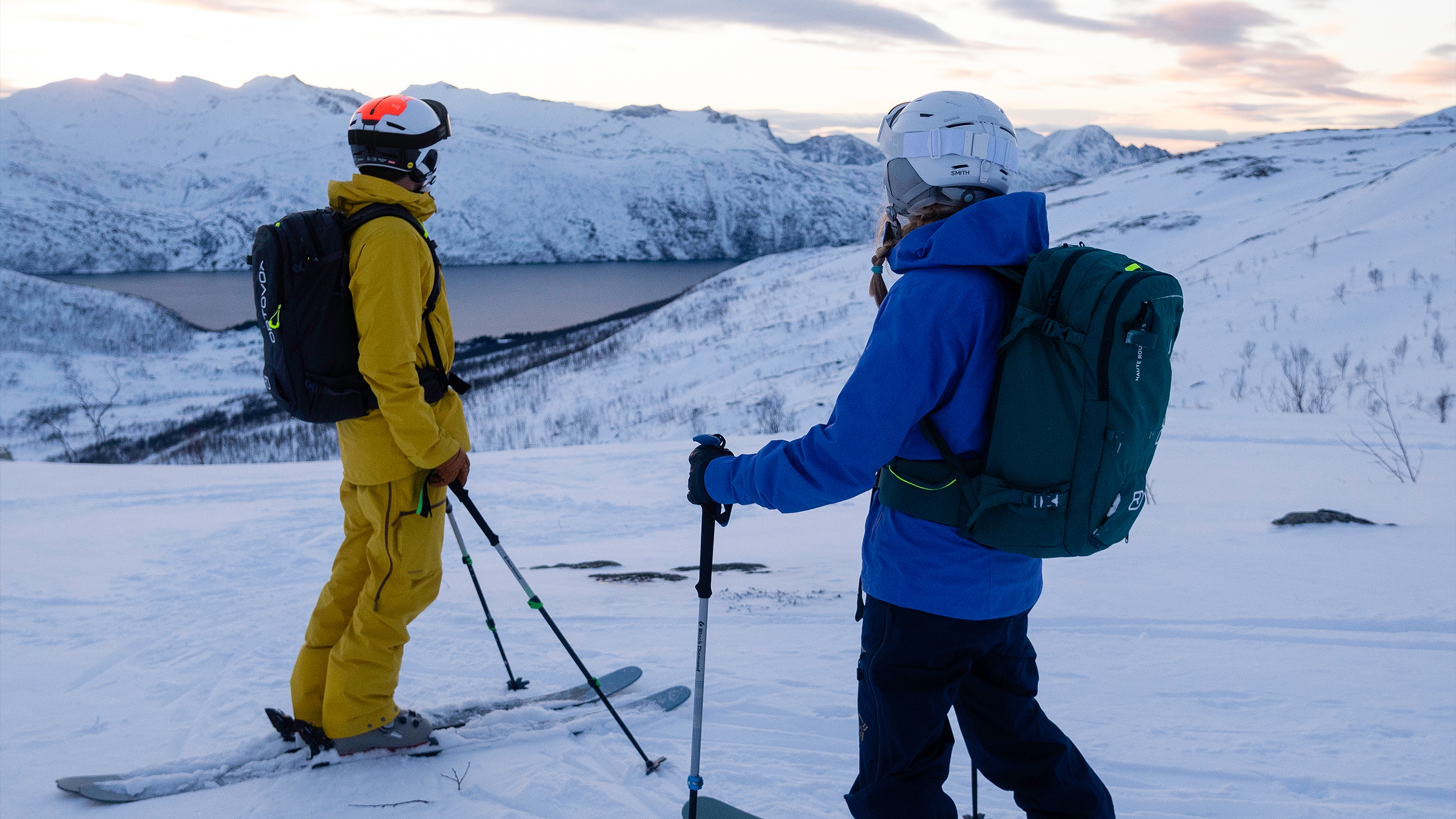 two skiers wearing avalanche backpacks