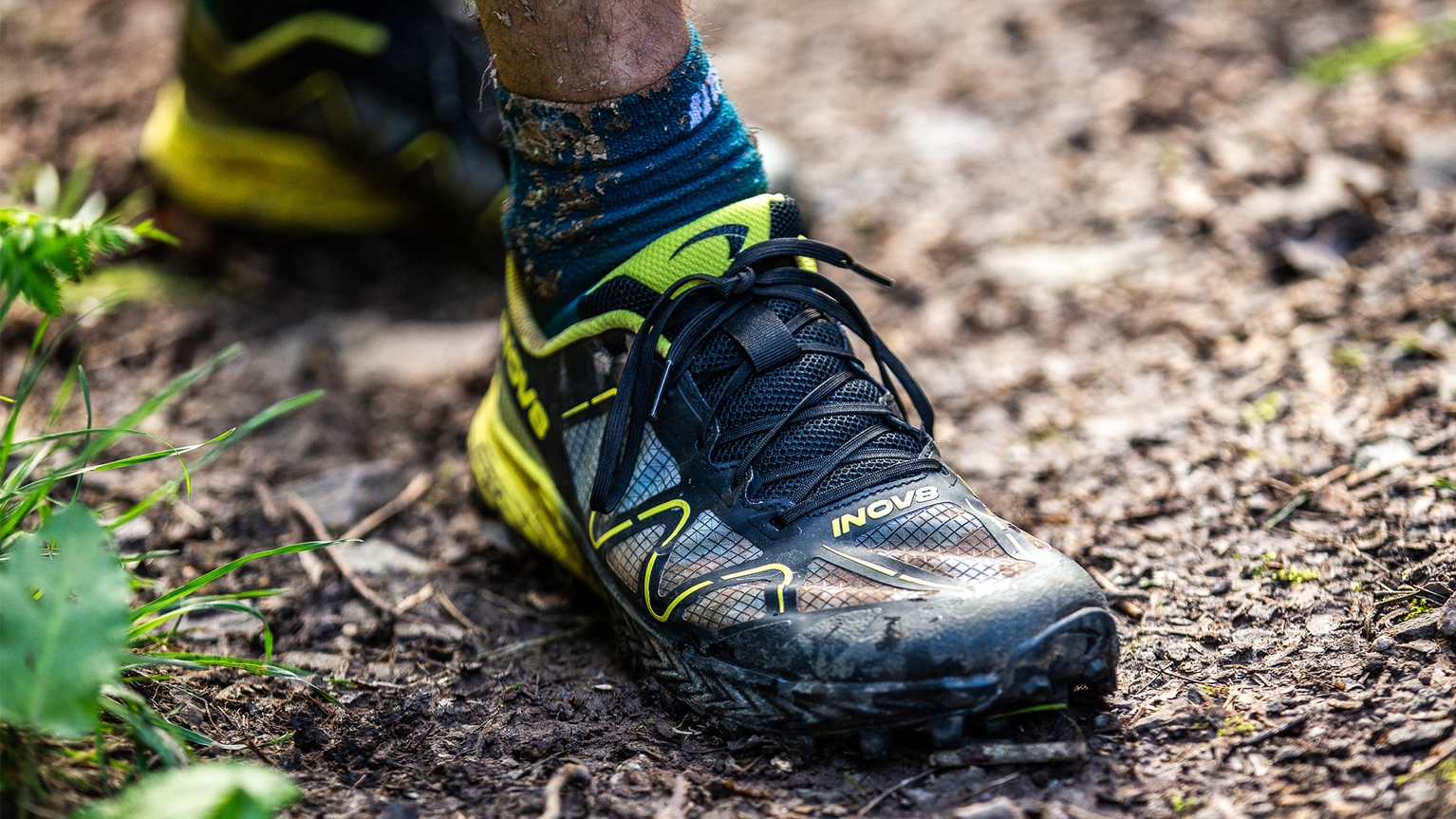 person wearing inov8 mudtalon running shoes
