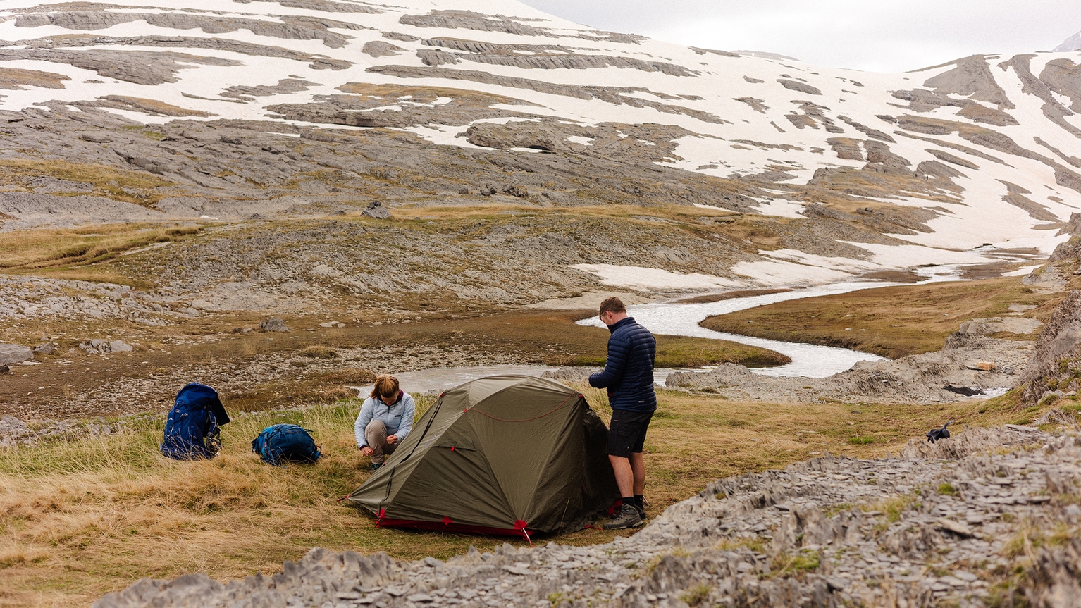 Two campers putting up a tent