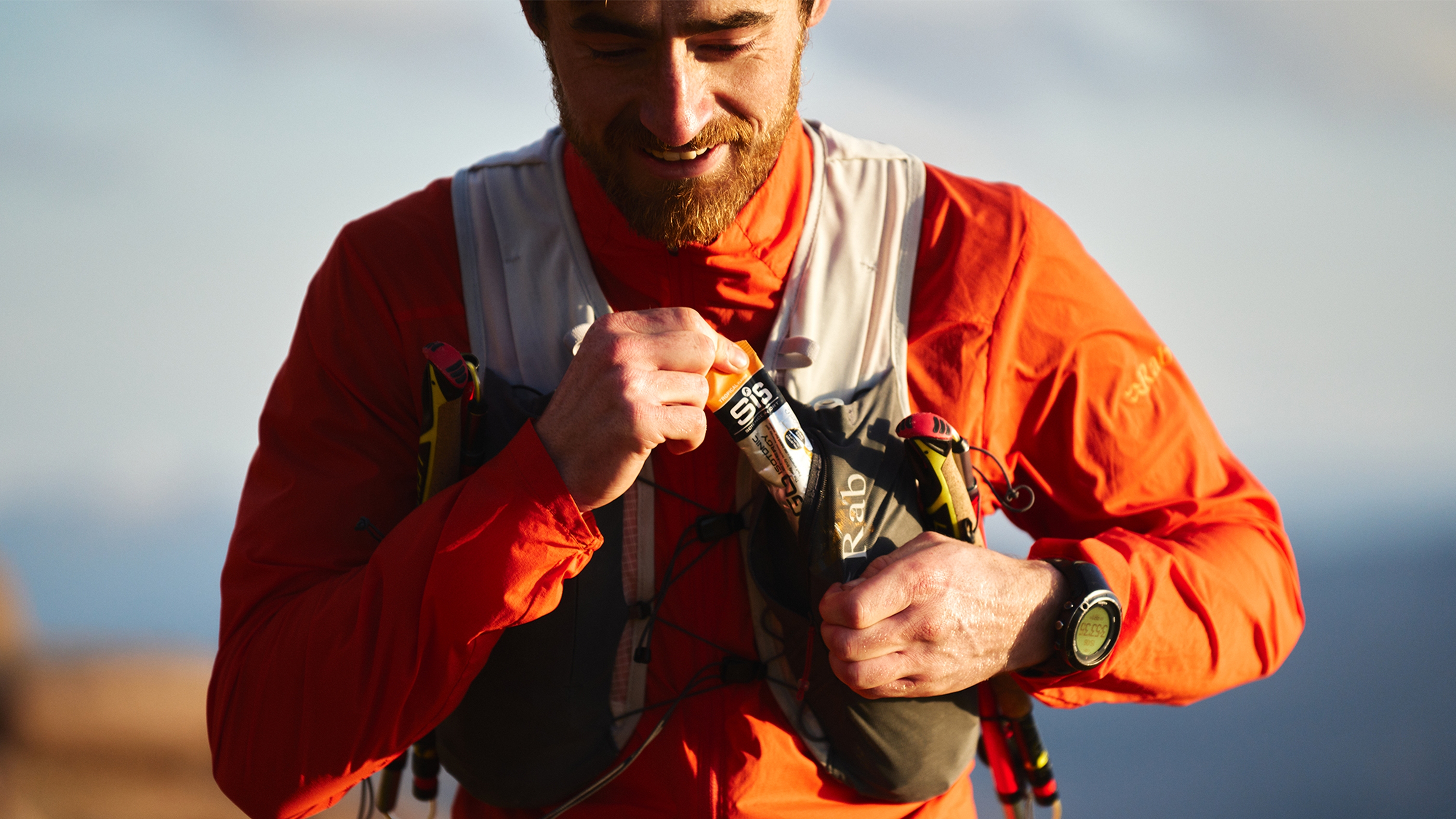 man pulling SIS energy gel out of a Rab veil 6 running vest