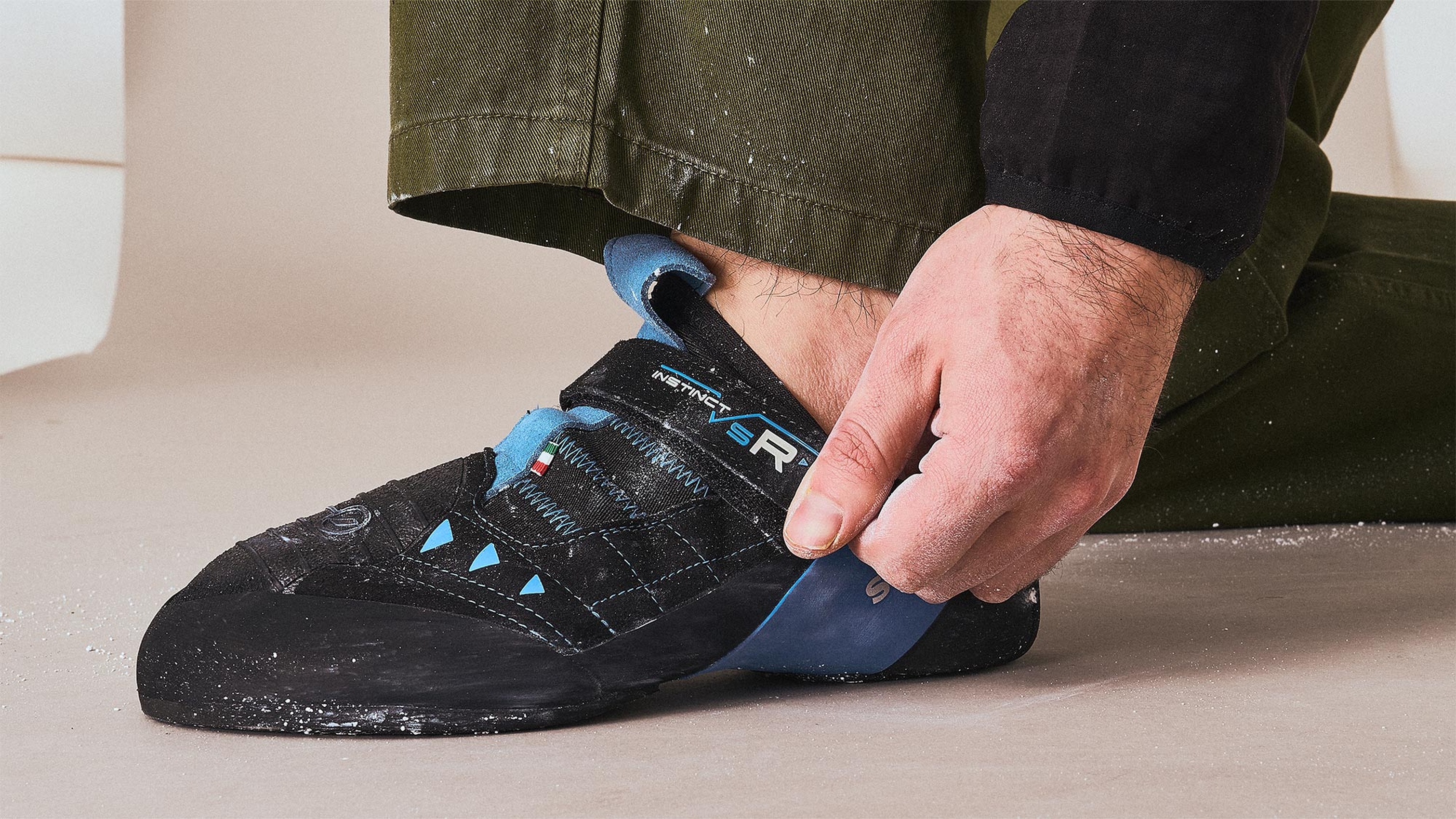 climber adjusting the velcro on their climbing shoes
