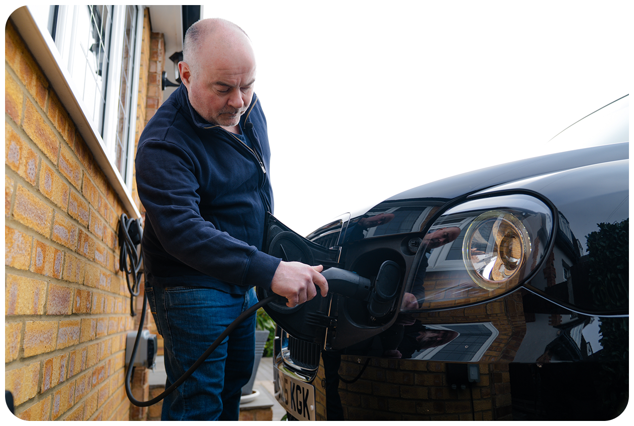 Declan, a taxi driver, plugs in his EV taxi