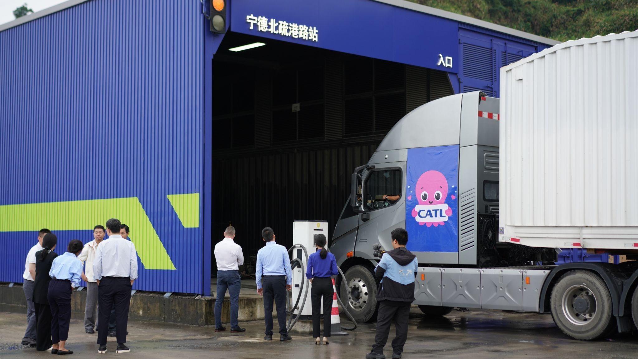 An electric truck pulls into a battery-swapping station
