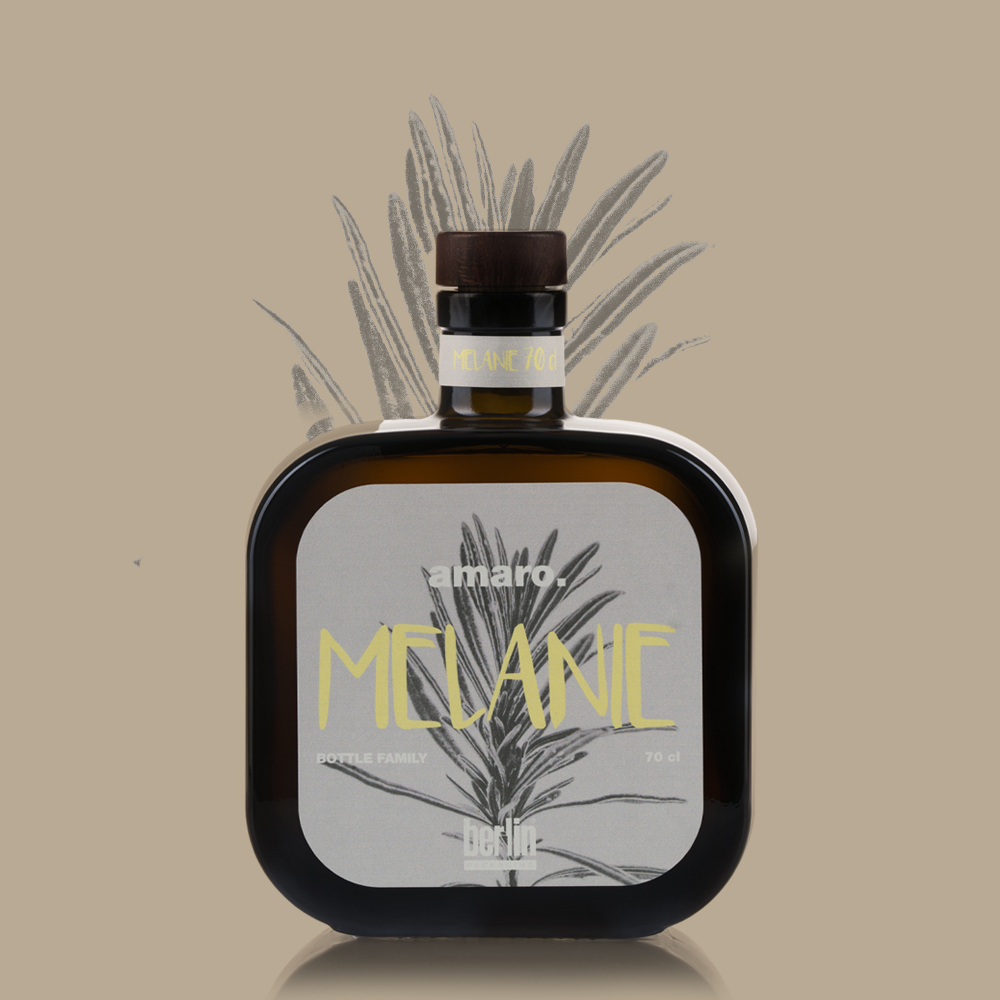 Square-shaped brown glass bottle of amaro labeled “Melanie” with sleek gray label and plant illustration, set on a beige background.