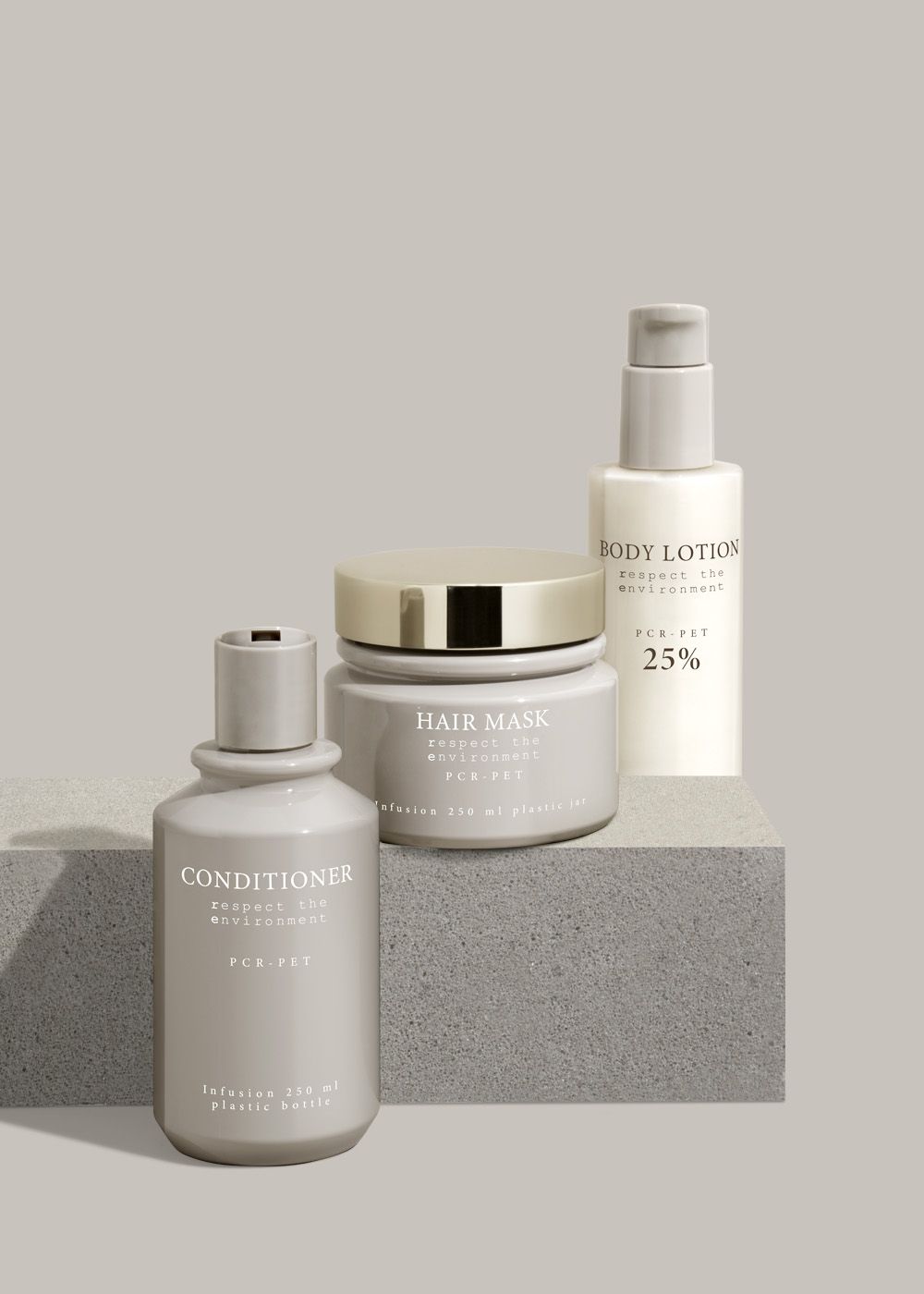 Three beige beauty products on a gray block: conditioner, hair mask, and body lotion, labeled "respect the environment."