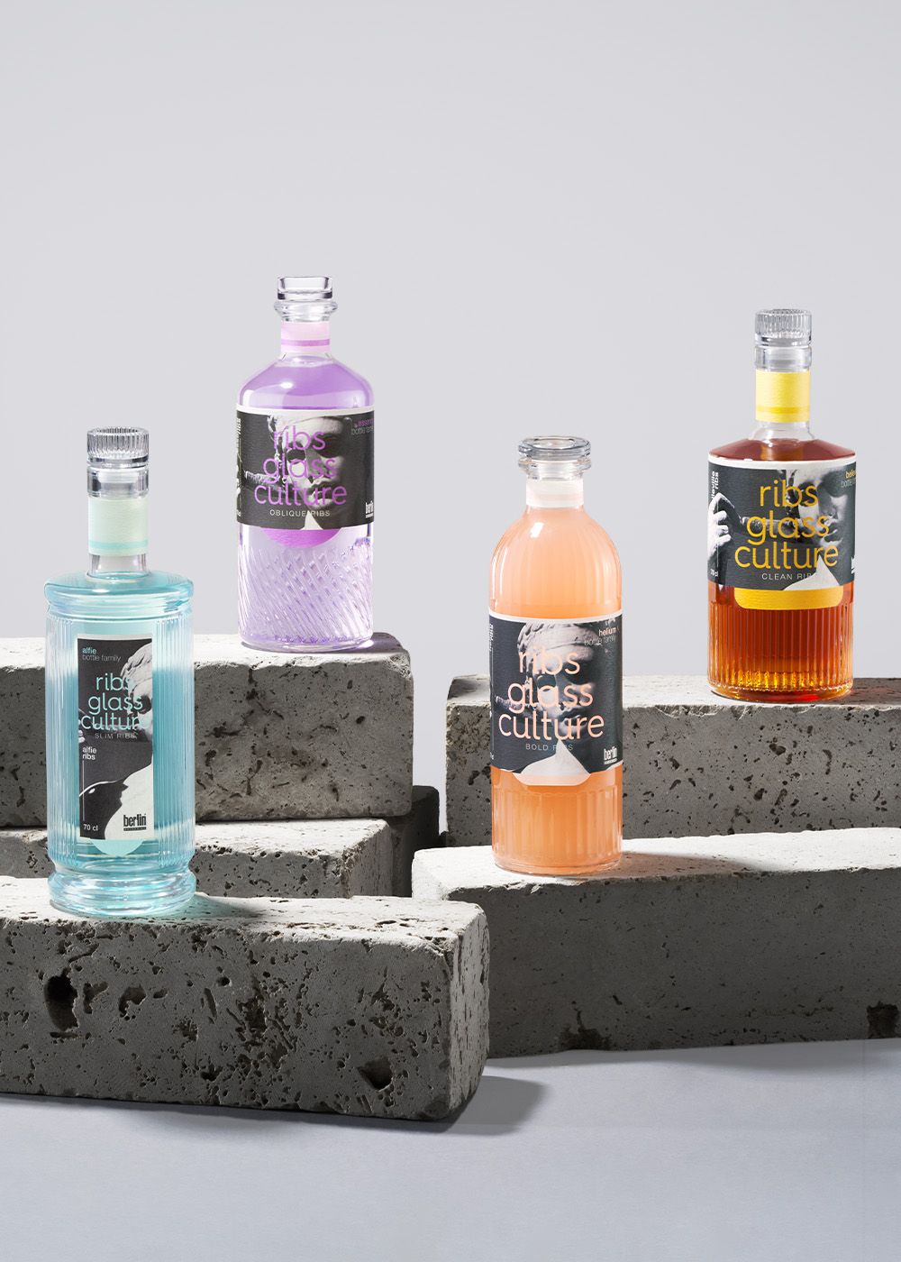 Ribs spirits collection bottles placed on stacked gray cinder blocks against a neutral background.