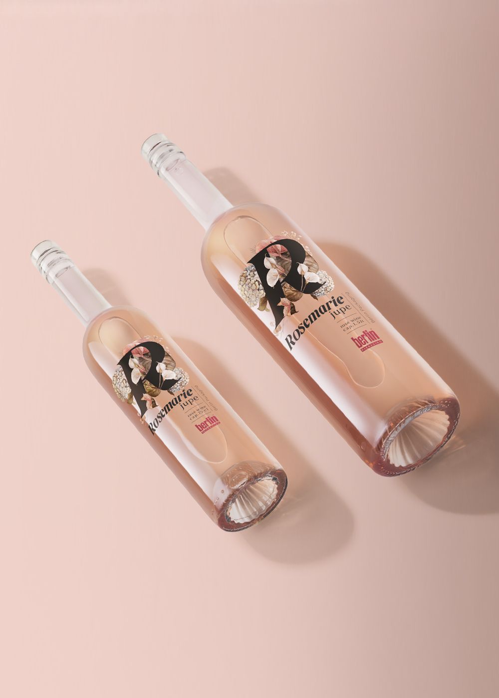 Two Rosmarie Jupe bottles with floral labels, placed on a light surface, casting soft shadows.