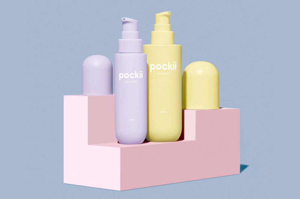 Set of bottles from the Pockii collection, suitable for both skincare and makeup, displayed on colorful geometric blocks, highlighting sustainable packaging
