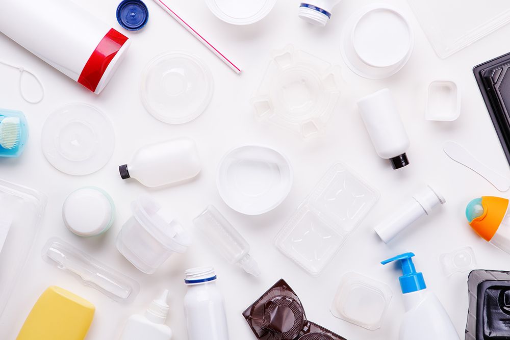 Assorted plastic packaging containers and bottles arranged on a white background.