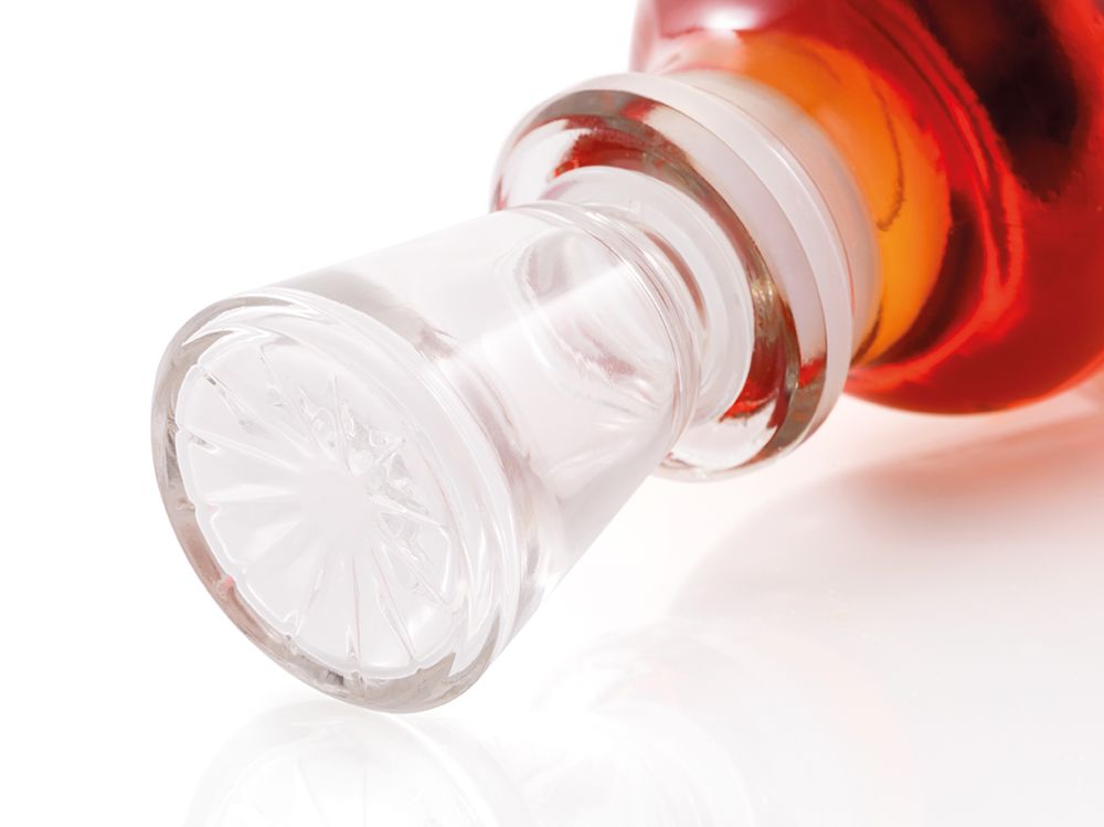 Detailed close-up of a custom-designed glass stopper from a premium pear spirits bottle.