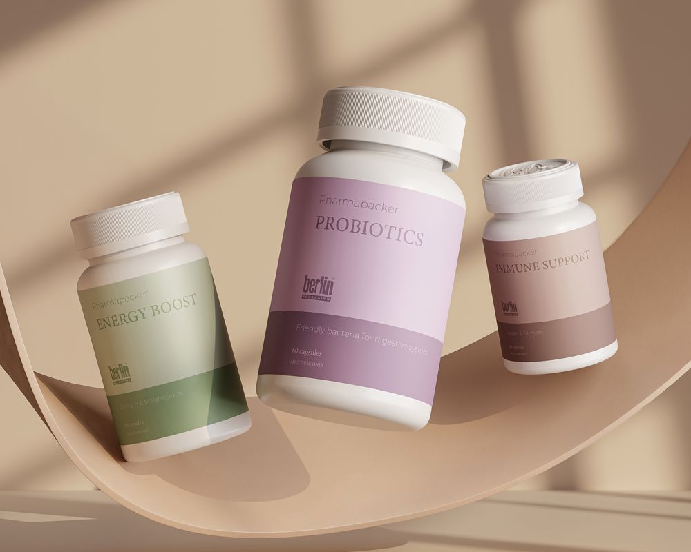 Three bottles of supplements labeled "Energy Boost," "Probiotics," and "Immune Support" displayed on a beige, abstract curved surface.