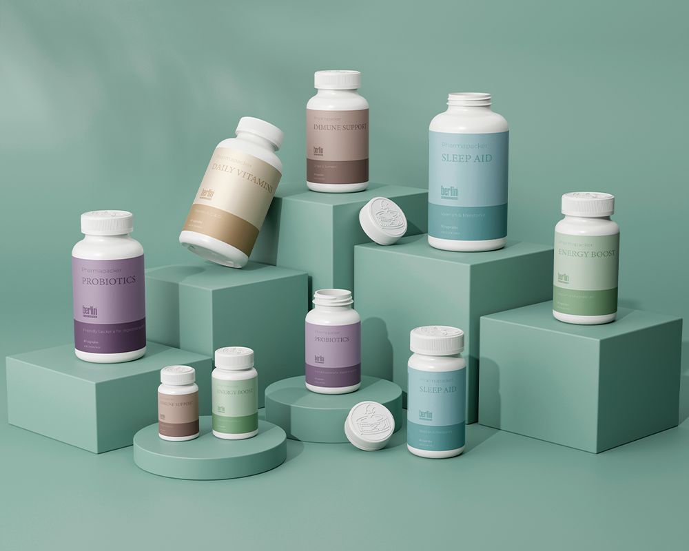 Various supplement bottles with different labels are displayed on teal platforms against a teal background.