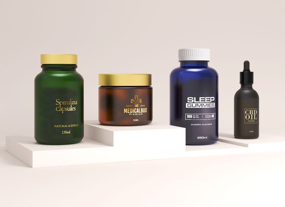 A display of wellness products on white platforms: Spirulina capsules, Medicabud jar, Sleep Gummies bottle, and a CBD oil dropper bottle. A display of wellness products on white platforms: Spirulina capsules, Medicabud jar, Sleep Gummies bottle, and a CBD oil dropper bottle.