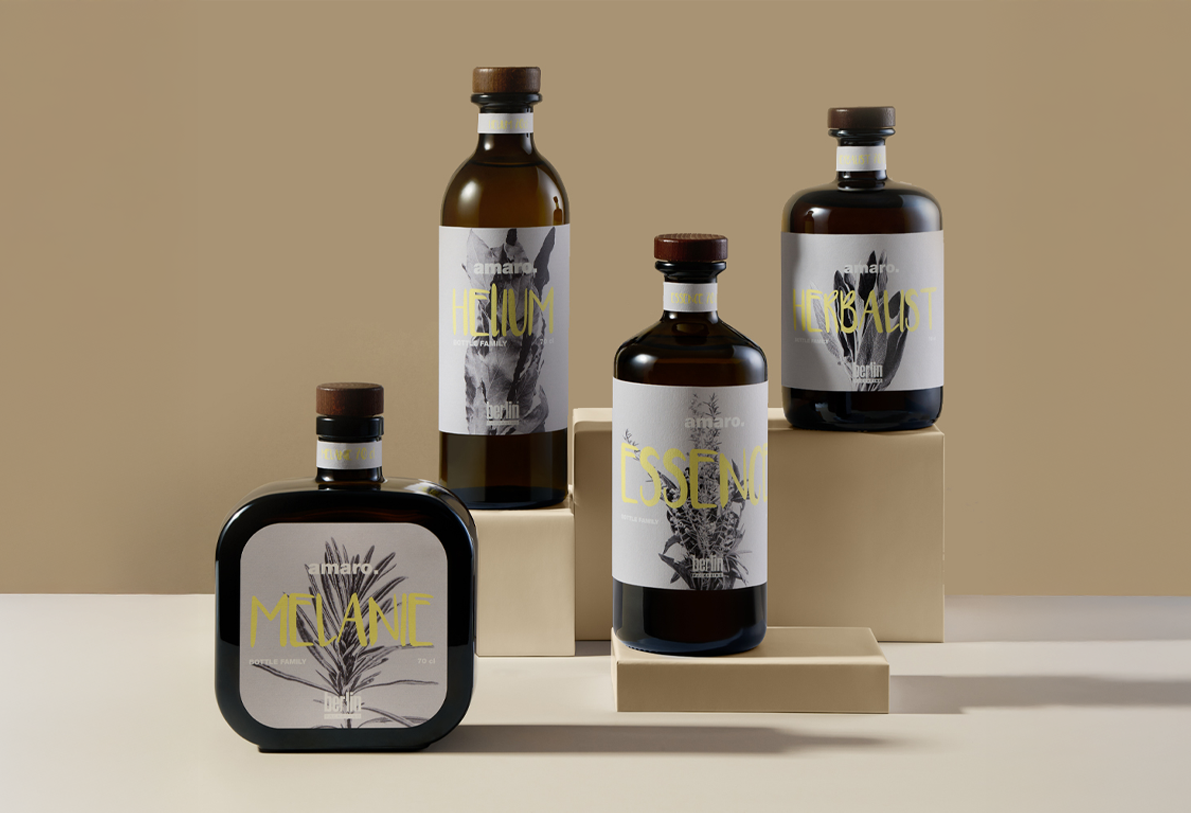 Collection of four amaro bottles—Helium, Essence, Herbalist, and Melanie—arranged on beige blocks against a neutral background, showcasing modern botanical label design packaging.