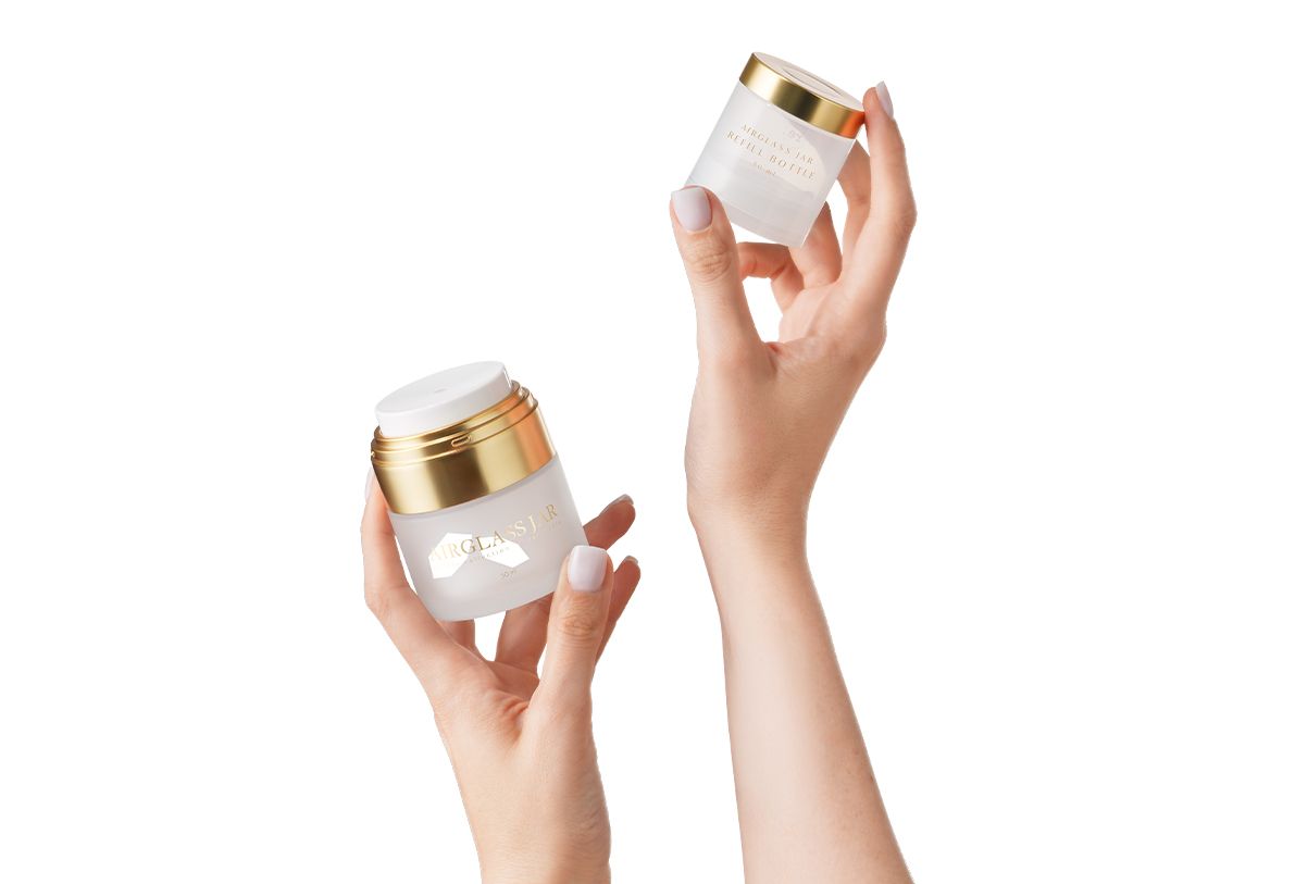 Airglass Jar 50 ml by Berlin Packaging Beauty, refillable airless glass jar with removable inner refill held by hands, illustrating reusable cosmetic packaging and sustainable beauty refill system.
