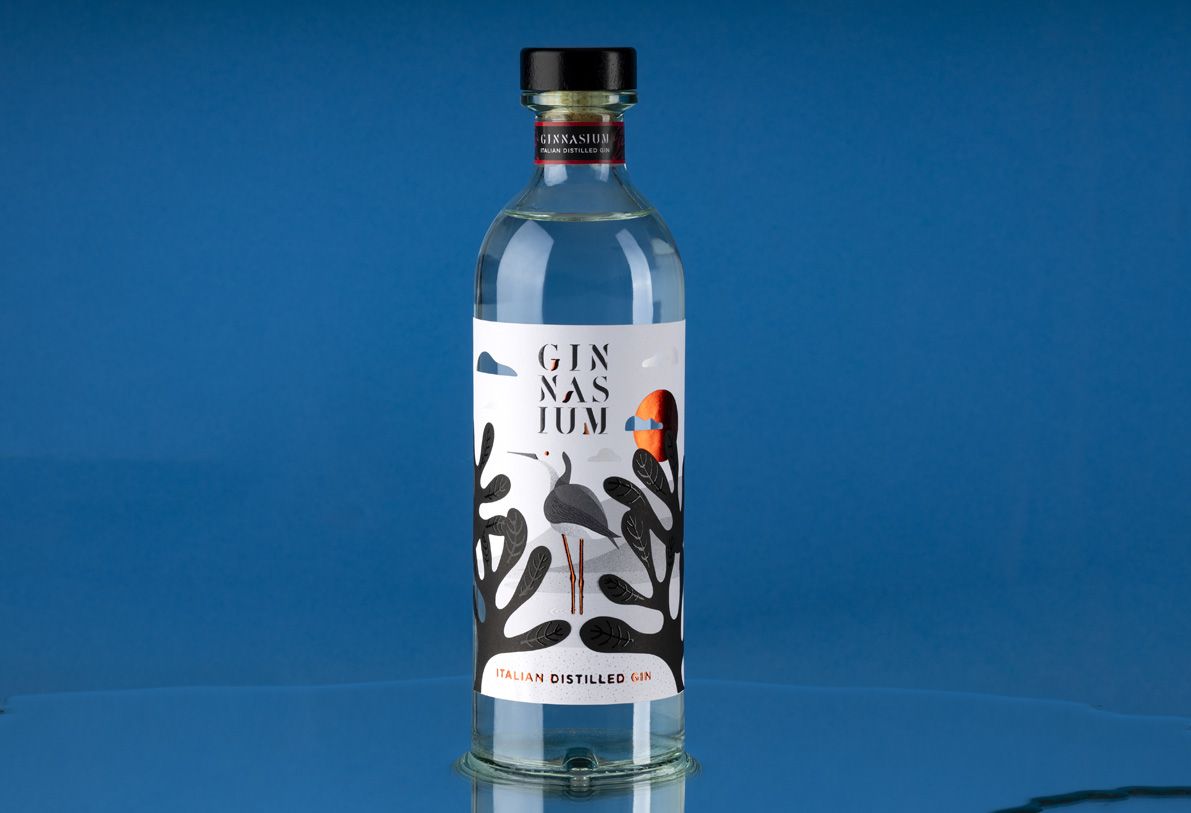 Helium Mixology 700 ml glass bottle for spirits by Berlin Packaging customized by Mark Design, created for the Ginnasium project, featuring a lightweight tall cylindrical silhouette and illustrated label with hot stamping details, inspired by apothecary perfume aesthetics.
