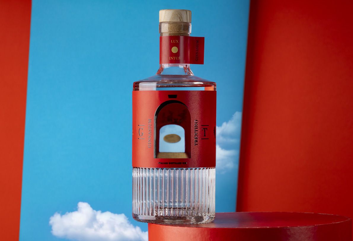 Belleville Ribs glass bottle for spirits by Berlin Packaging customized by Killer Idea, created for the Ginnasium project, featuring bold red wrap label and ribbed glass base for distinctive packaging design.
