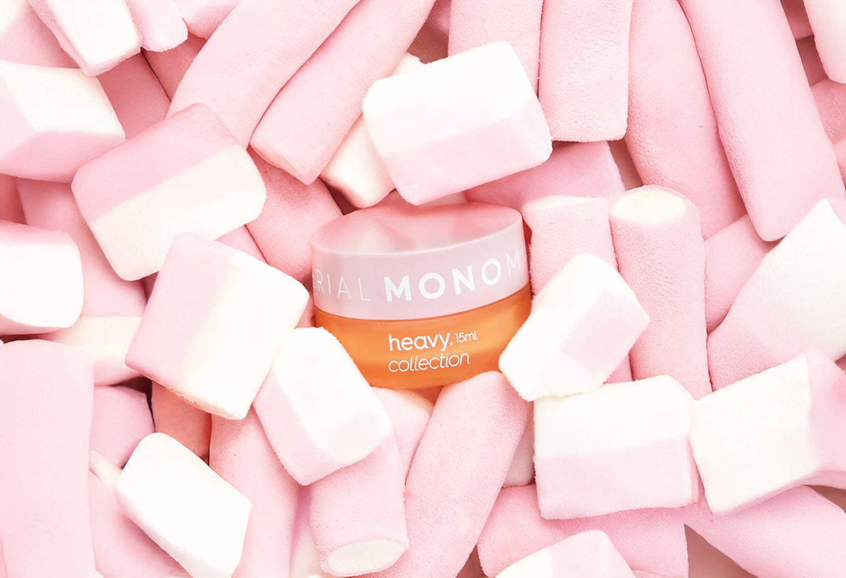 Heavy Collection 15ml cosmetic jar with pink lid, surrounded by soft pink and white marshmallows, on a bright pastel background.