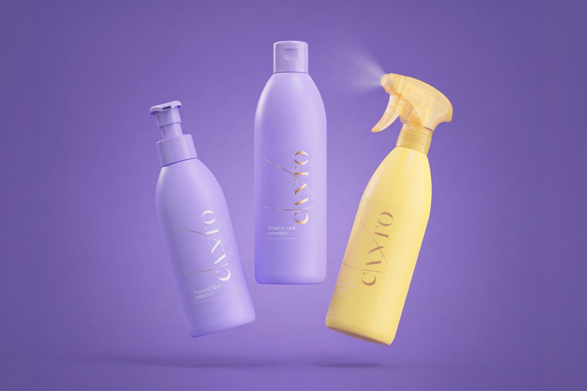 Three personal care bottles are floating against a purple background, two in lavender and one in yellow, with a spray nozzle in use.