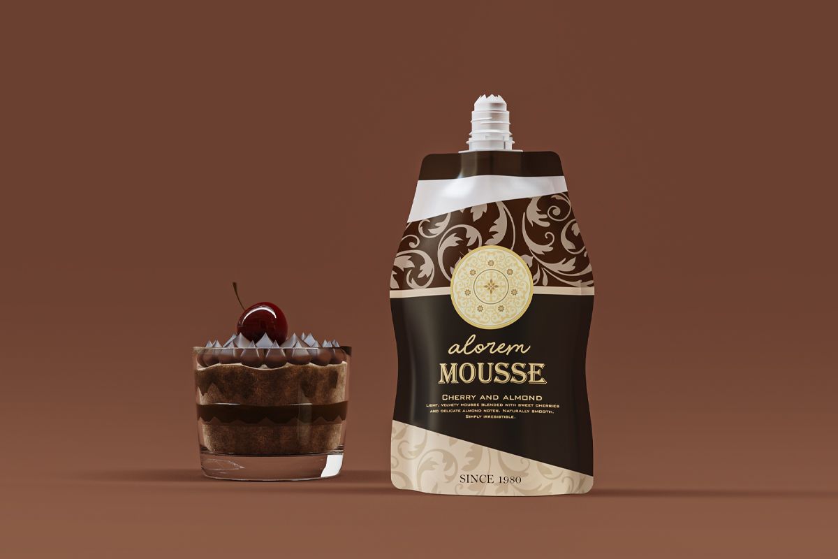 Single spout pouch labeled “Alorem Mousse – Cherry and Almond” in black and gold design, placed next to a glass dessert topped with whipped cream and a cherry, set against a brown background. Single spout pouch labeled “Alorem Mousse – Cherry and Almond” in black and gold design, placed next to a glass dessert topped with whipped cream and a cherry, set against a brown background.