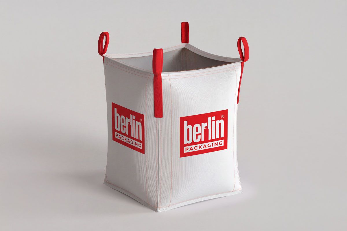 White bulk bag with red straps and "Berlin Packaging" logo, designed for transporting materials, standing on a neutral background.