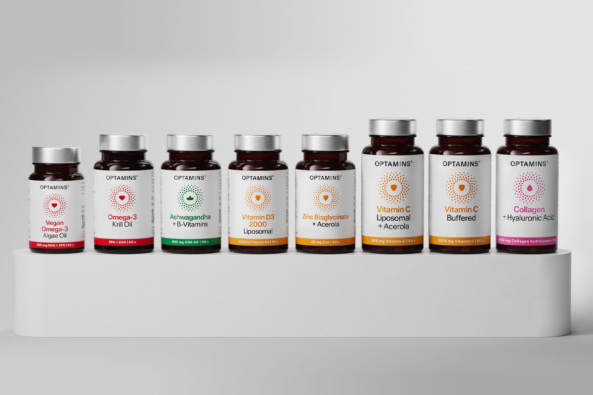 A display of Optamins supplement bottles showcasing various vitamins, minerals, and health products on a tiered white shelf. A display of Optamins supplement bottles showcasing various vitamins, minerals, and health products on a tiered white shelf.