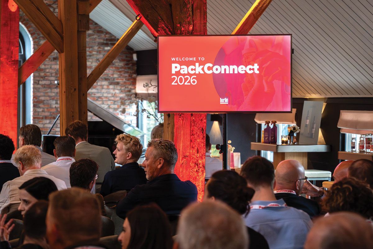 Audience at PackConnect 2026 event, seated in a room with a large screen displaying the conference title in a modern setting.