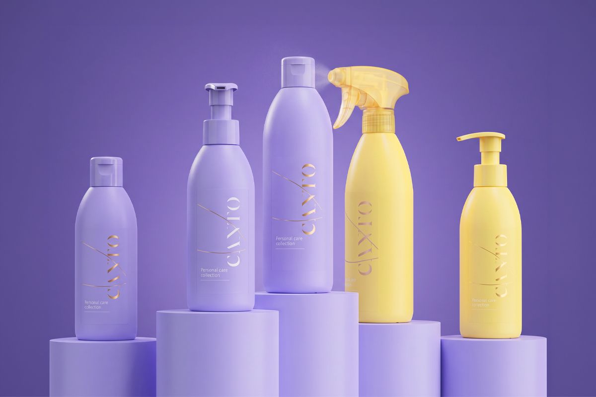 Five personal care bottles, three lavender and two yellow, arranged on purple cylindrical platforms against a purple background.