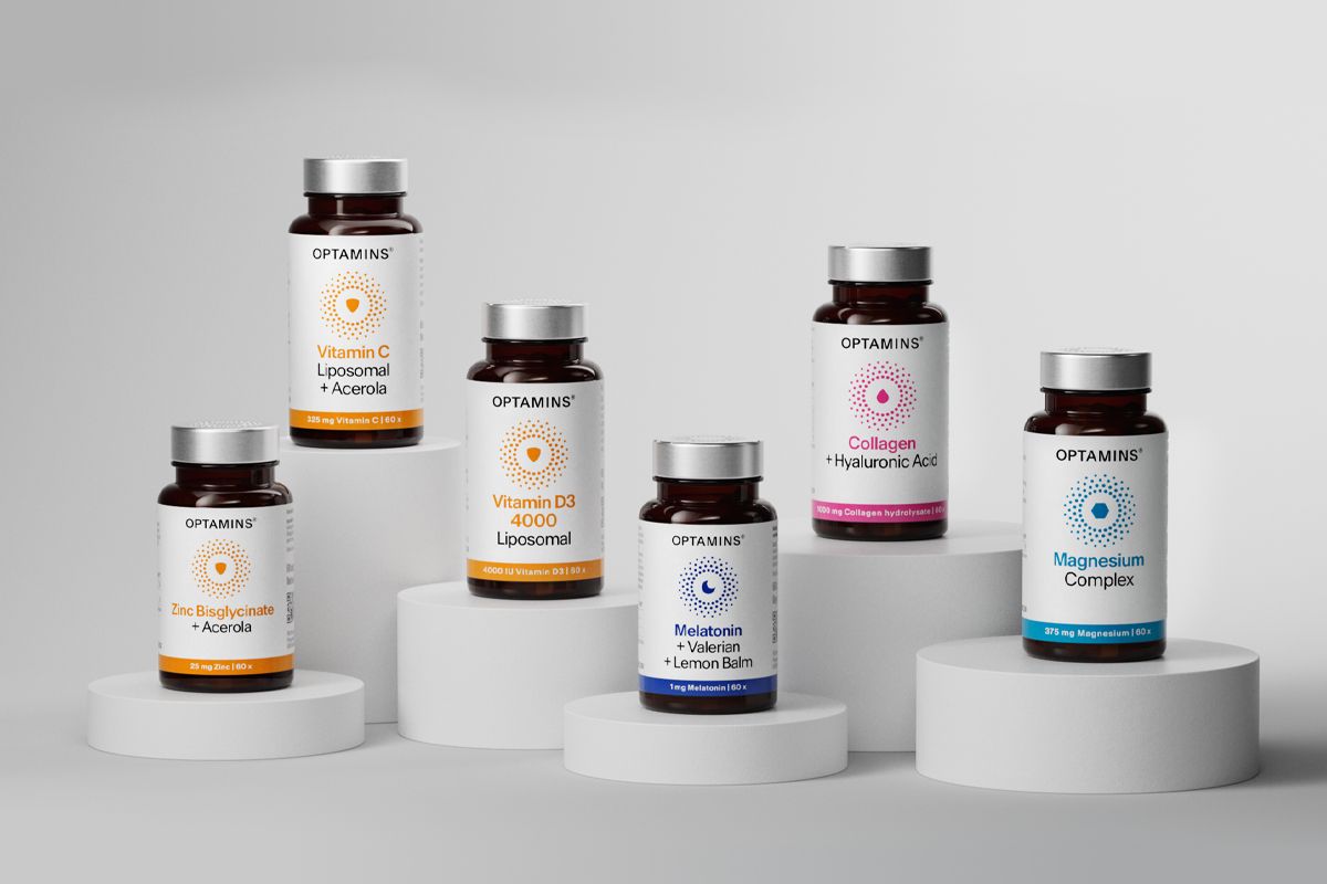 Five OPTAMINS supplement bottles on white cylindrical stands, including Collagen, Vitamin D3, Vitamin C, Magnesium, and Vegan Omega-3.
