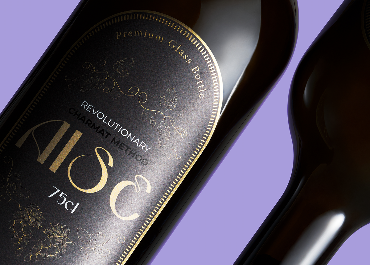 Aise glass bottle by Berlin Packaging, close-up of premium label featuring gold decorative elements, botanical-inspired graphics and refined finishing details for sparkling wine packaging.