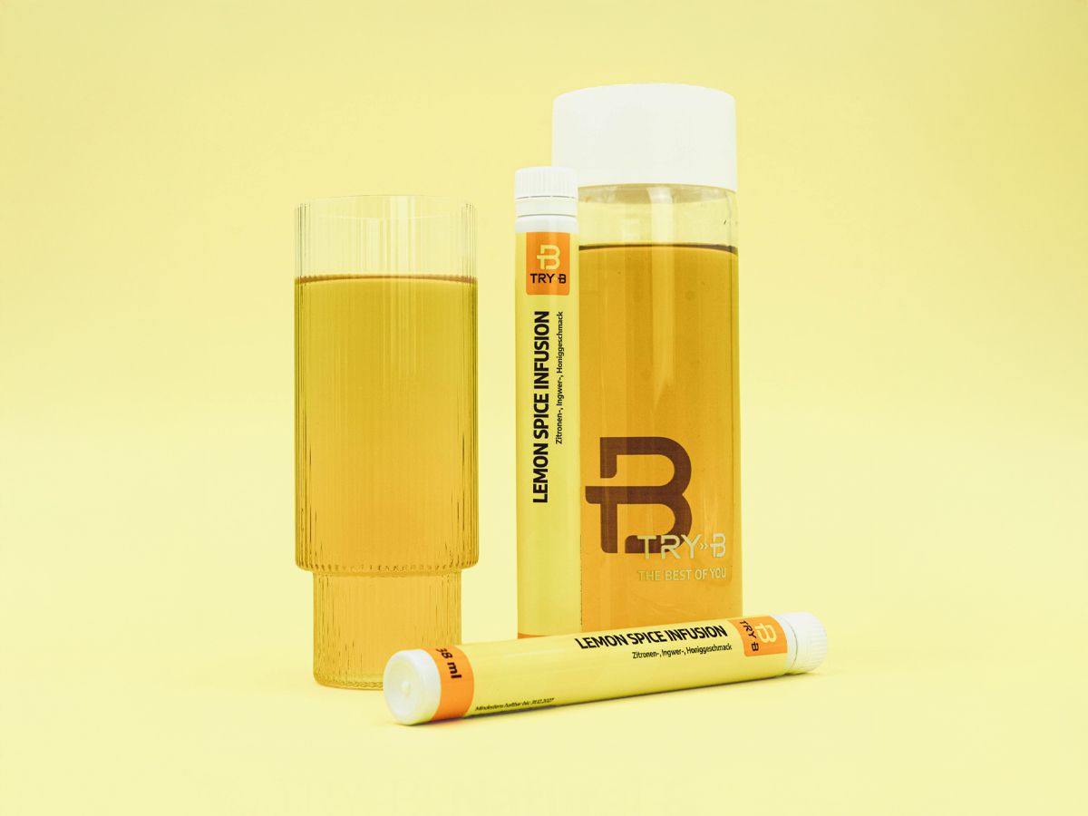 TRY-B Lemon Spice Infusion shown with a filled glass and a branded clear bottle on a yellow background, with two 20 ml Lemon Spice Infusion sticks placed upright and lying in front