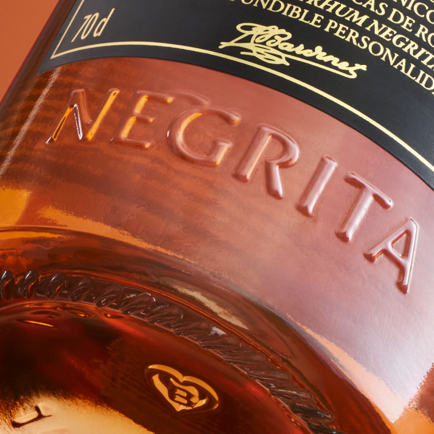 Close-up of Negrita Bardinet rhum bottle with embossed text "NEGRITA" and intricate gold label details, including a logo and elegant script.