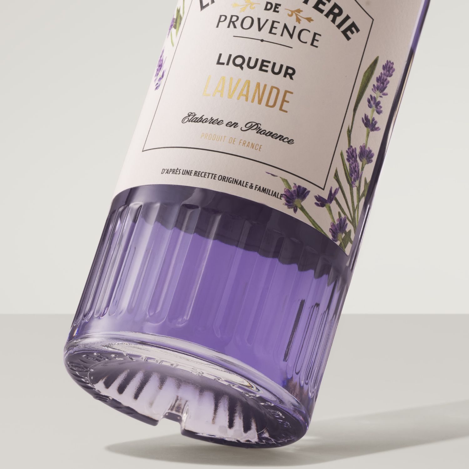 Helium Ribs bottle by Berlin Packaging for Liquoristerie de Provence, with a decorative label showing lavender flowers, filled with purple liquid.